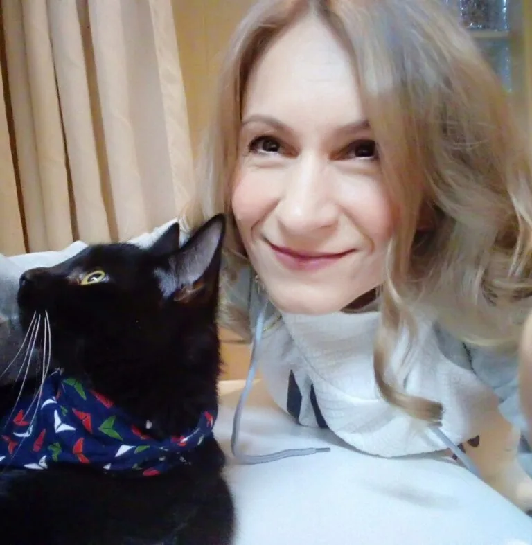 Edit Szóráth smiling cheek to cheek with her black cat
